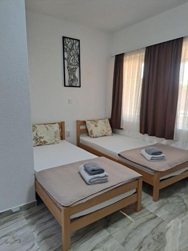 two twin beds in a room with windows at A-Niko Apartments in Vinica