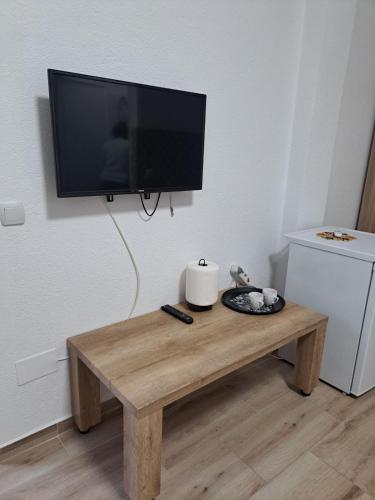 a flat screen tv hanging on a wall above a coffee table at A-Niko Apartments in Vinica