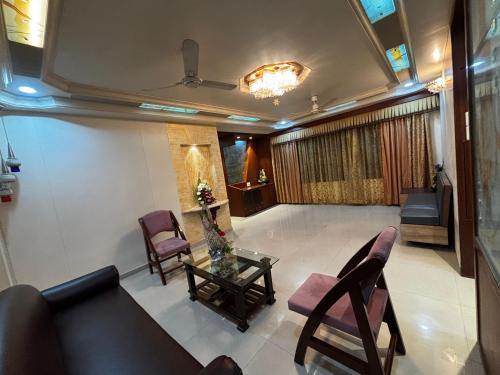 a living room with a couch and chairs and a table at JK Rooms 149 Thakur Galaxy in Nagpur