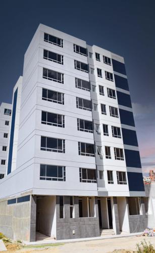 a tall white building with a lot of windows at Sibauty Suites in La Paz