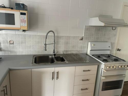 a kitchen with a sink and a stove at Apartment in great location Murray Street in North Ward