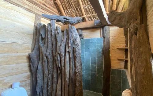 a bathroom with a wooden wall with a toilet at Cabaña ecologica en el Rio Cocorna, Puerto Triunfo in Providencia