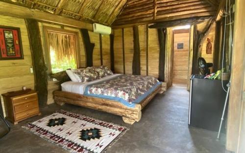 a bedroom with a bed in a wooden cabin at Cabaña ecologica en el Rio Cocorna, Puerto Triunfo in Providencia