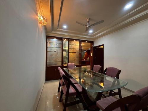 a dining room with a glass table and chairs at JK Rooms 149 Thakur Galaxy in Nagpur