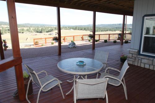 a patio with a table and chairs on a deck at Sawin' Logs Inn in Devils Tower