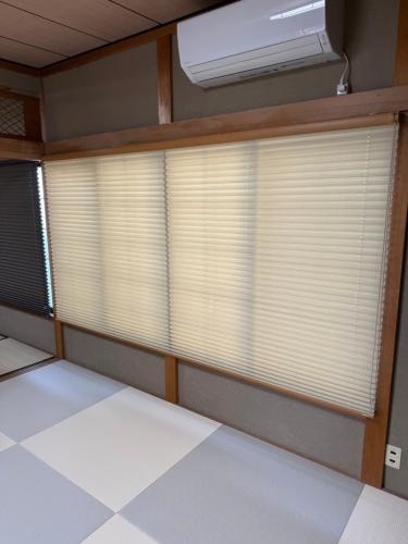 an empty room with a window with blinds at 自然体験と石窯のある古民家民泊アジールAsyl in Hirosaki