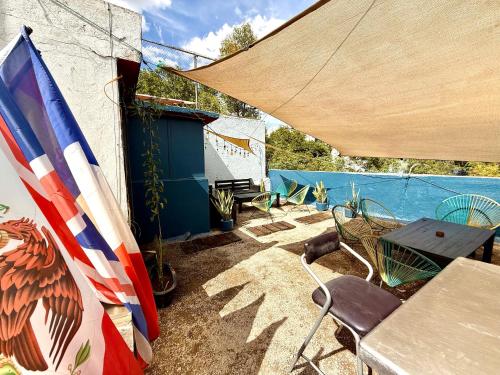 a patio with a table and chairs and an umbrella at RMS Hostal - Condesa in Mexico City