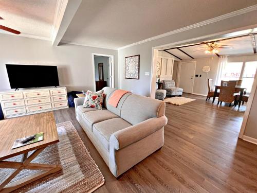 a living room with a couch and a flat screen tv at Oakridge Cottage in Orange Beach