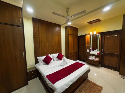 a bedroom with a large bed with red pillows at JK Rooms 149 Thakur Galaxy in Nagpur