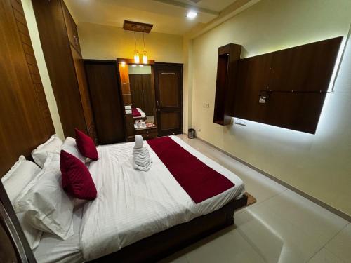 a bedroom with a large bed with red pillows at JK Rooms 149 Thakur Galaxy in Nagpur