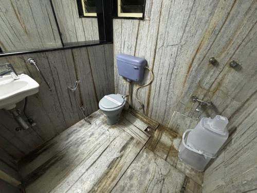a wooden bathroom with a toilet and a sink at JK Rooms 149 Thakur Galaxy in Nagpur