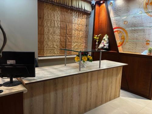 a reception desk with a vase of flowers on it at JK Rooms 149 Thakur Galaxy in Nagpur