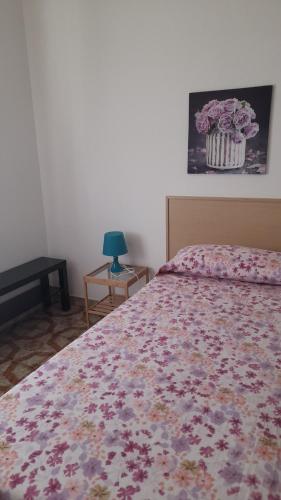 a bedroom with a bed with a floral bedspread at Belvedere Experience Apartment in Caprioli