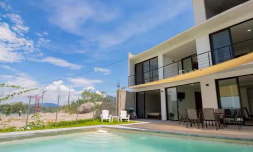 a house with a swimming pool in front of a building at New Bamboo Kuri Pool and Fun in Tequesquitengo
