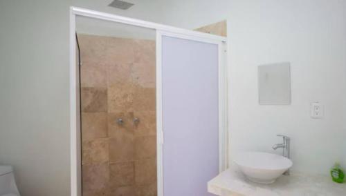 a white bathroom with a sink and a shower at New Bamboo Kuri Pool and Fun in Tequesquitengo