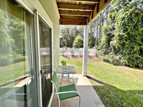 a porch with two chairs and a table on it at Laguna Breeze in Gulf Shores