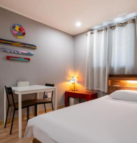 a bedroom with a bed and a table and a desk at Stay Hyun in Jeju