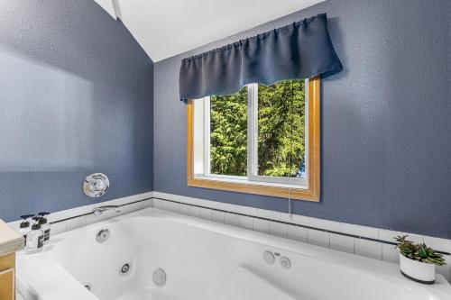 una bañera en un baño con ventana en Longhorn Hideaway by Casago McCall - Donerightmanagement, en McCall