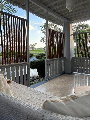 a porch with a hammock and a view of a river at villa Angin in Munggu