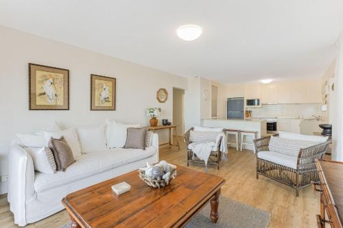 a living room with a white couch and a table at Beach Lodge Unit 5 in Gold Coast