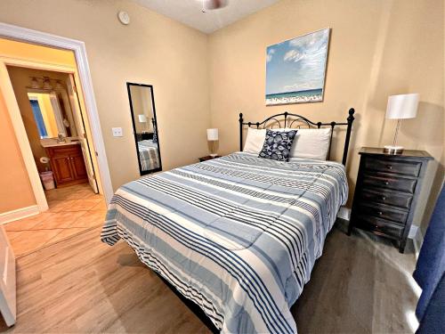 a bedroom with a bed with a striped blanket at Laguna Breeze in Gulf Shores