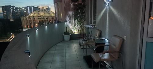 a room with a balcony with a table and chairs at Top Point Chisinau Apartment in Chişinău