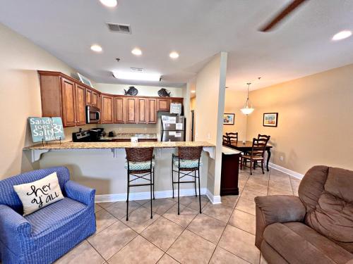 a kitchen and living room with a counter and chairs at Laguna Breeze in Gulf Shores