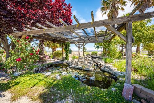 a wooden pergola over a pond in a garden at Hilltop Oasis in Templeton
