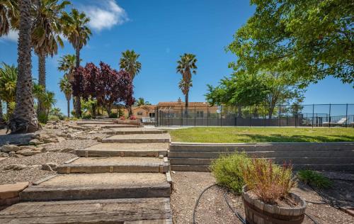 a garden with steps and palm trees and a building at Hilltop Oasis in Templeton
