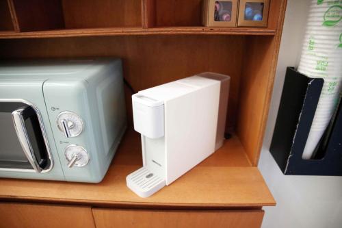 a microwave and a toaster sitting on a shelf at Pyeongtaek 1981 in Pyeongtaek