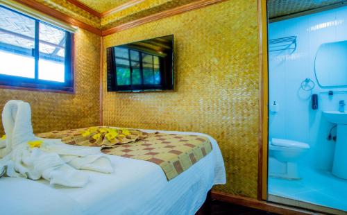 a bedroom with a bed and a toilet and a window at Puerto Pension Inn in Puerto Princesa City