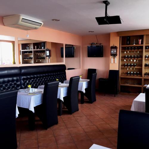 a dining room with tables and chairs and wine bottles at Hotel Freiburg in Ulcinj