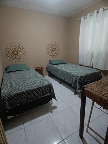 a room with two beds and a table in it at Casa super aconchegante in Parnaíba