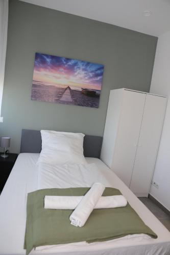 a white bed with two towels on top of it at Ok Apartments in Pforzheim
