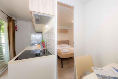 a small bathroom with a sink and a bedroom at Mobilehomes in Sirmione - Gardasee 22177 in Sirmione