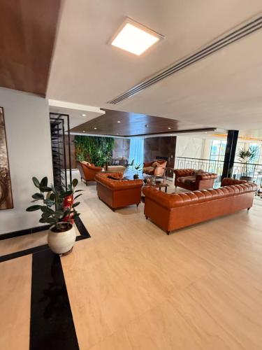 a living room with brown leather couches at Resort Gran Paradiso - apartamento com vista in Campos do Jordão