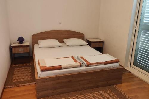 ein Schlafzimmer mit einem Holzbett mit Handtüchern darauf in der Unterkunft Apartments with parking space Orebic, Peljesac - 24769 in Orebić