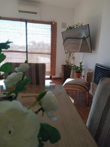 a dining room with a table with flowers on it at Alojamiento Las Camelias in Concordia