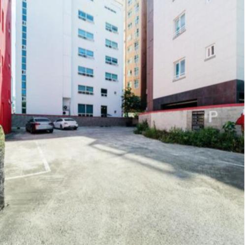a parking lot in front of two tall buildings at Stay Hyun in Jeju