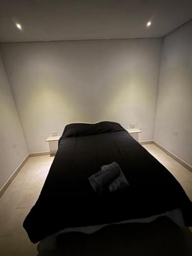 a black bed in a room with two tables at ALTOS DEL MIRADOR b in Patagones