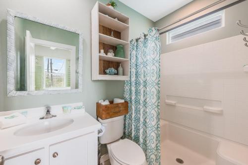 Un baño con lavabo, inodoro y ducha. en Caney Creek Beach Club, en Mustang Beach