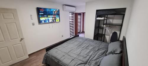 a bedroom with a bed and a flat screen tv at Casa cómoda y completa con 2 camas king size y 1 cama twin in Ciudad Juárez