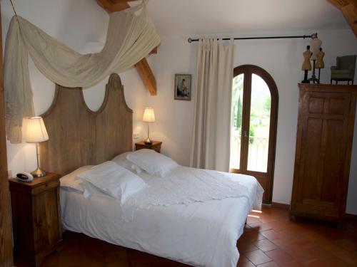 a bedroom with a white bed and a window at La Ferme Rose-Hôtel de Charme in Moustiers-Sainte-Marie