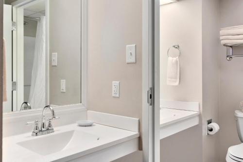 Un baño blanco con lavabo y espejo. en Top Floor Family Deluxe Bay View, en North East