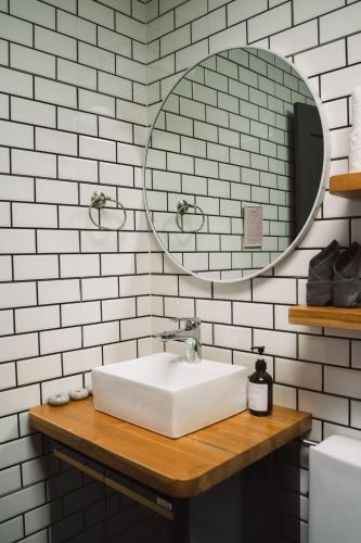 a white bathroom with a sink and a mirror at Baan Pila in Luang Prabang