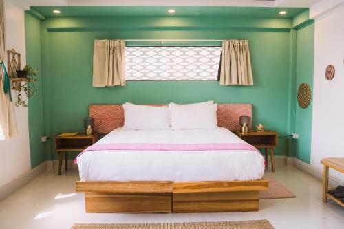 a bedroom with a bed with a green wall at Baan Pila in Luang Prabang