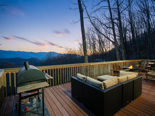 a patio with a couch and a grill on a deck at Lazy Bear Retreat Mountain Views-Hot Tub-FirePit in Whittier