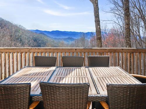 a wooden table and chairs on a deck with a view at Lazy Bear Retreat Mountain Views-Hot Tub-FirePit in Whittier