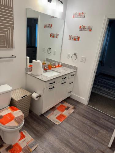a bathroom with a toilet and a sink and a mirror at Cozy Contemporary Condo in Atlanta