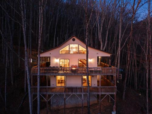 a large house with a large deck in the woods at Lazy Bear Retreat Mountain Views-Hot Tub-FirePit in Whittier